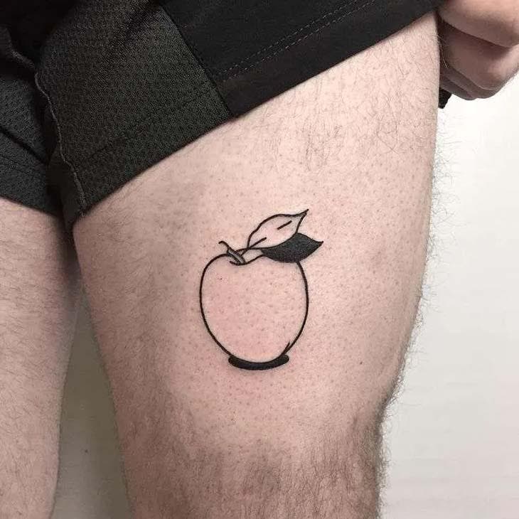 Tatouage d’une pomme sur la cuisse d’un homme