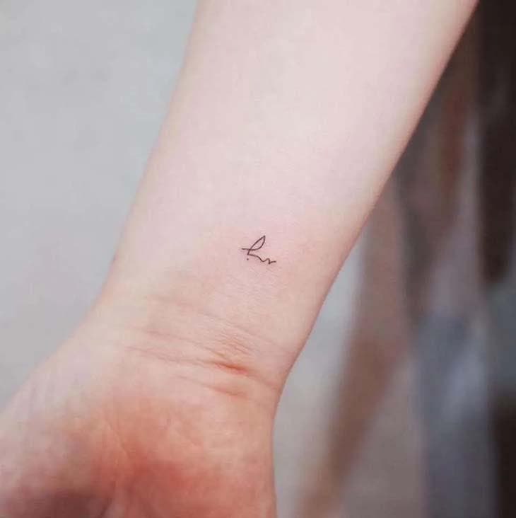 Signature minimaliste tatouée sur le torse