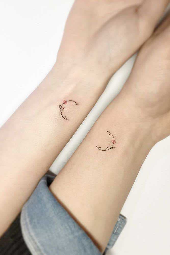 Deux tatouages représentant des demi-cercles avec une petite fleur