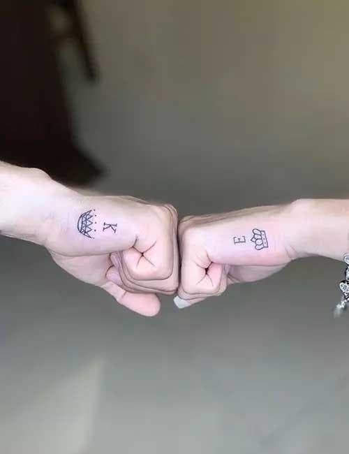 Deux petits tatouages sur la main représentant les couronnes du roi et de la reine