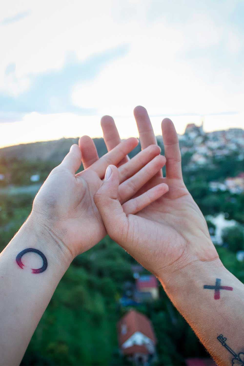 Deux tatouages représentant une croix et un zéro