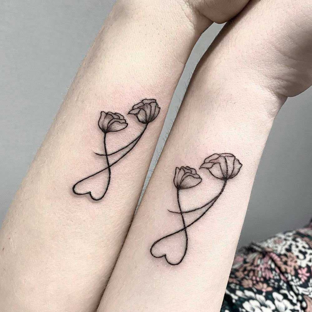 Deux tatouages similaires représentant deux fleurs qui s'entremêlent pour former un cœur