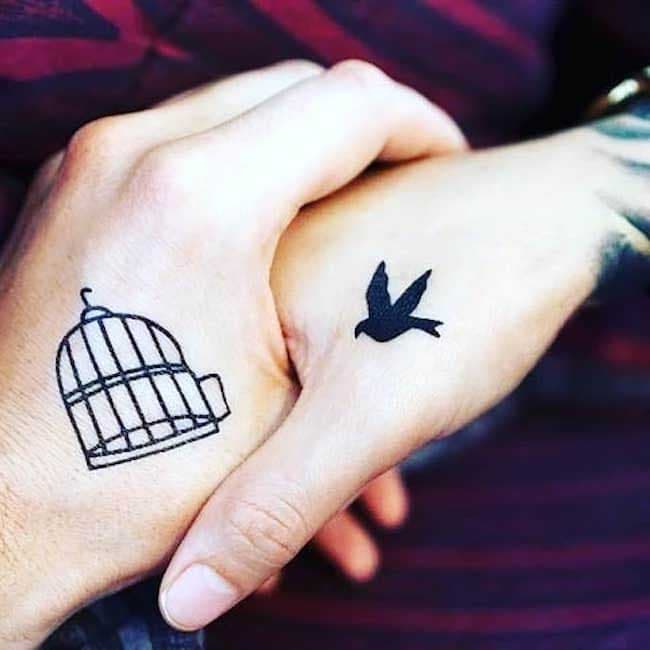 Deux tatouages représentant une cage ouverte d’un côté et un oiseau qui se dirige vers elle d’un autre