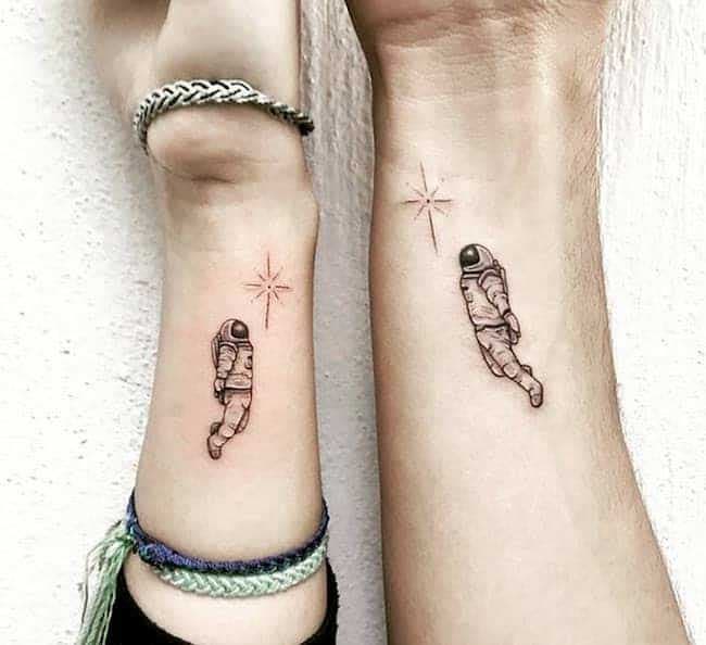 Deux tatouages similaires représentant un astronaute qui flotte dans l’espace en direction d’une étoile
