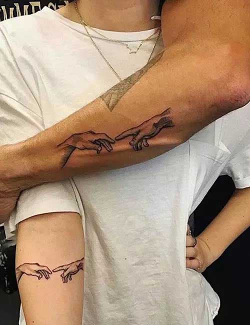 Deux tatouages similaires représentant deux mains qui tentent de se toucher