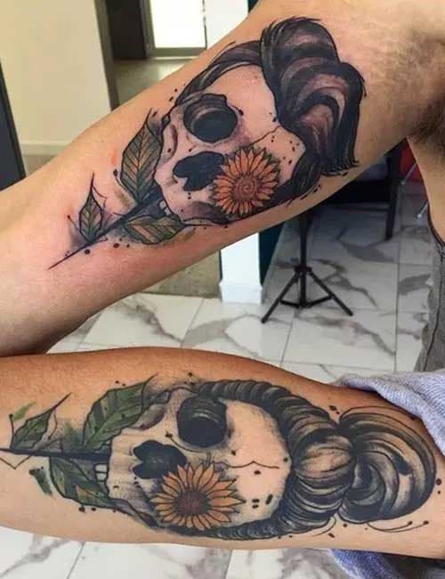 Deux tatouages représentant des têtes de morts avec une fleur de tournesol qui sort d’une des orbites des yeux
