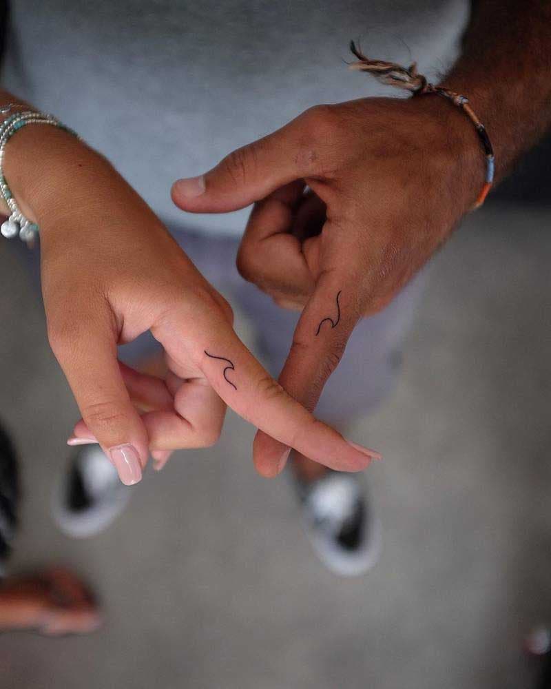 Deux tatouages minimalistes similaires représentant deux vagues