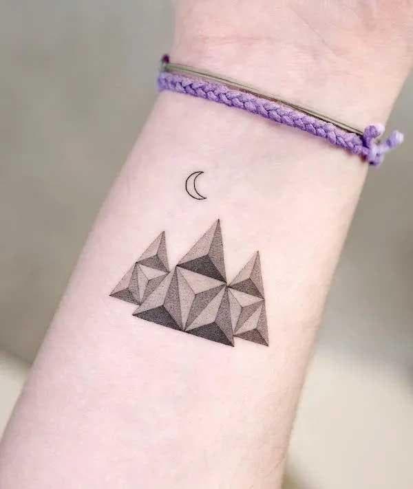 Montagnes géométriques en tatouage sur l’avant bras
