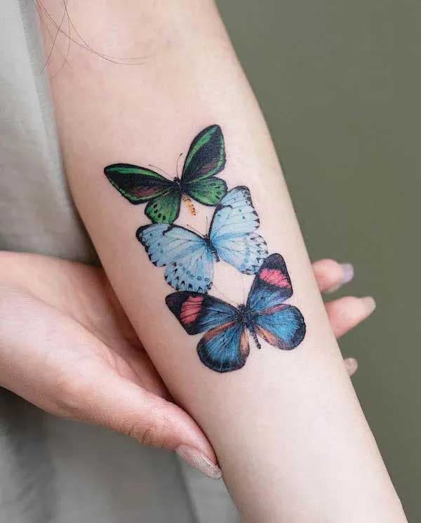 Papillons colorés tatoués sur l’avant bras