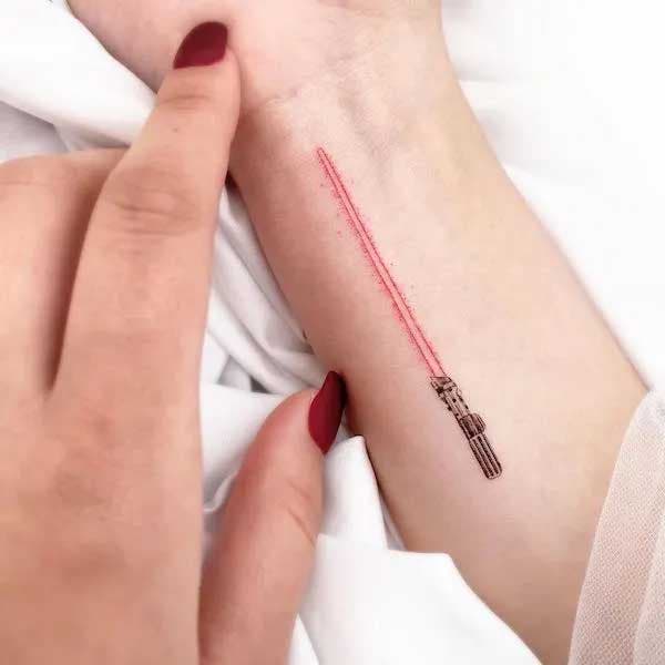 Sabre laser tatoué sur le bras