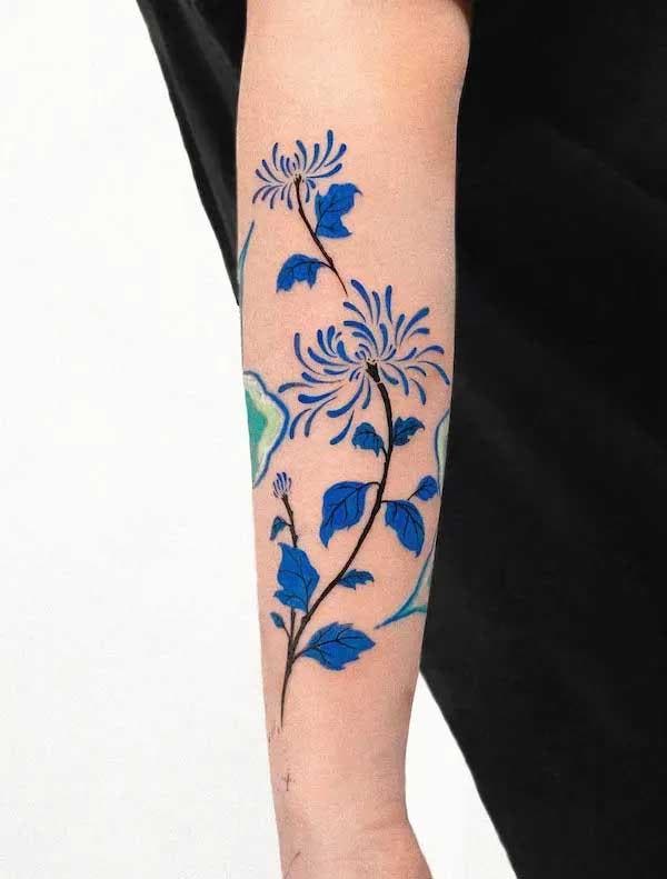 Fleurs bleues tatouées sur l’avant bras