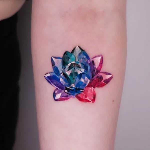 Tatouage lotus en cristal sur l’avant bras