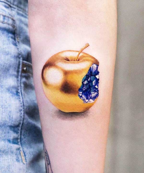 Pomme en cristal tatoué sur l’avant bras