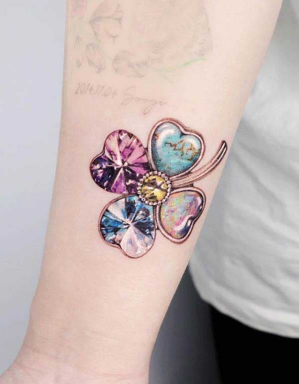 Trèfle en bijoux tatoué sur l’avant bras