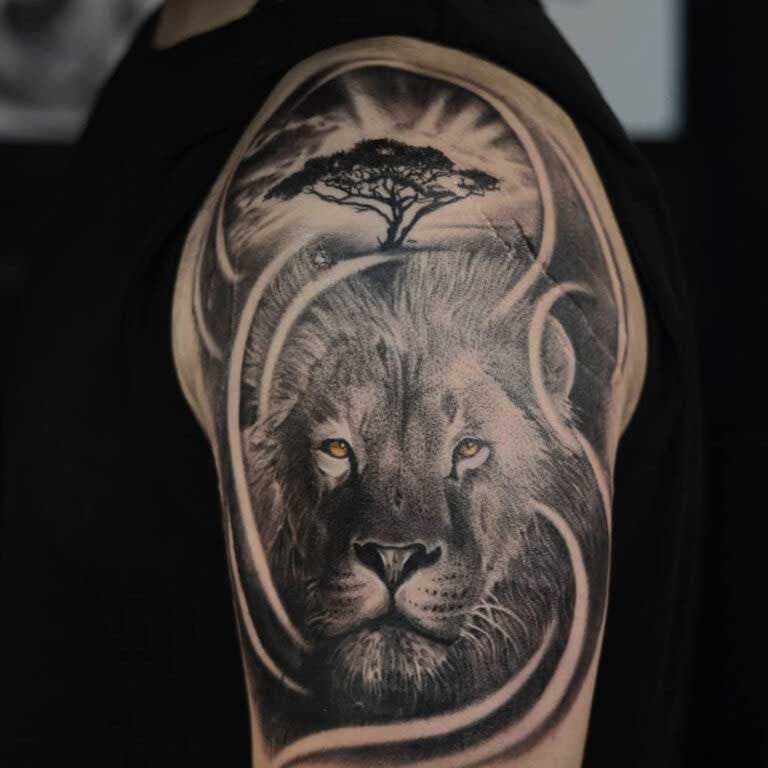 Tatouage de lion dans la savane sur le haut du bras 