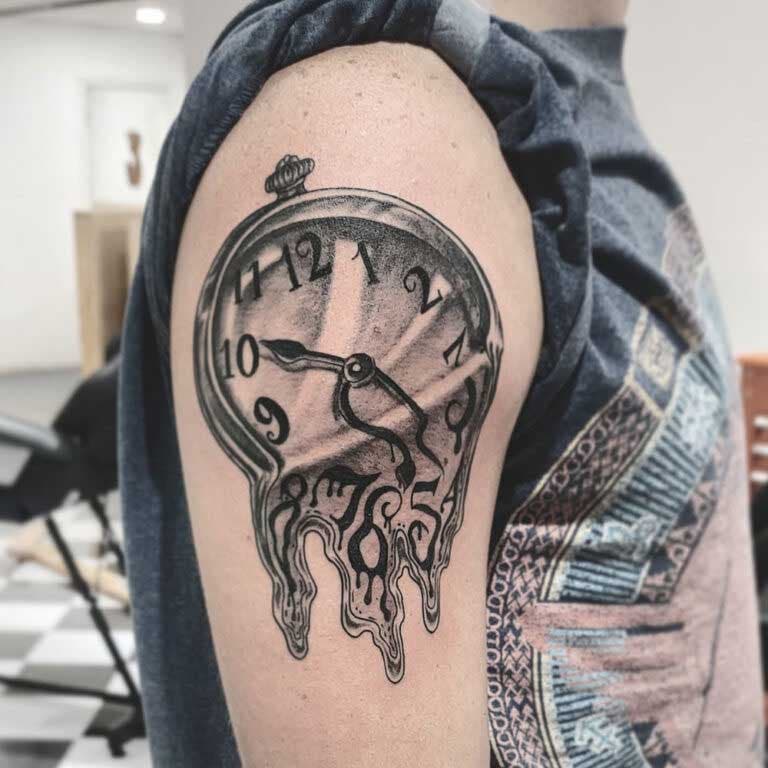 Tatouage d’une montre de poche sur le haut du bras 