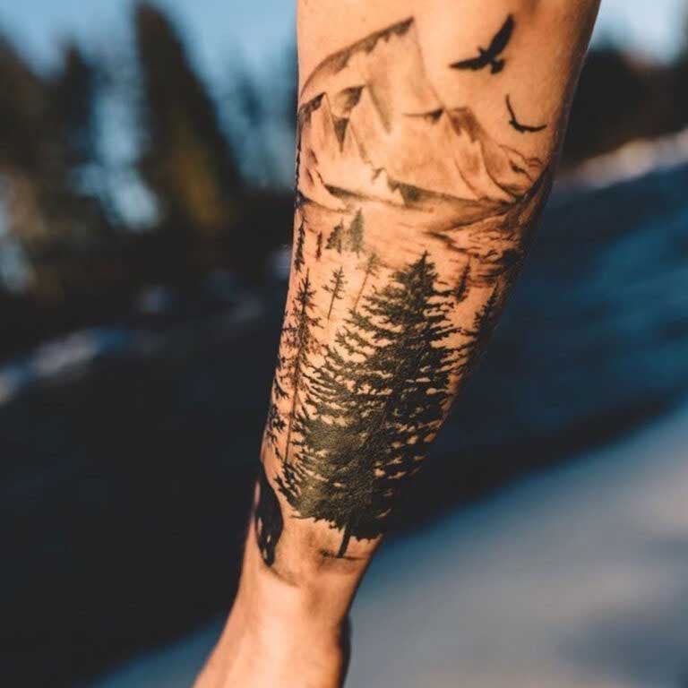 Tatouage d’un paysage montagneux sur l’avant-bras