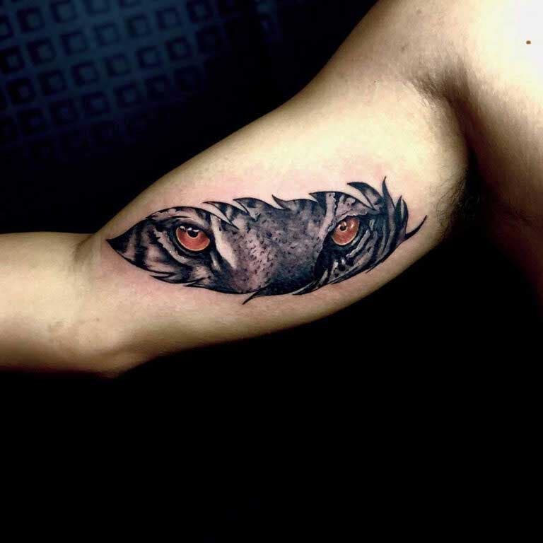 Tatouage de bras avec un tigre regardant à travers un motif de plume