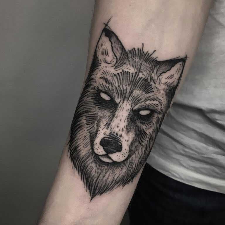 Tatouage d’une tête de loup stylisée sur l’avant-bras