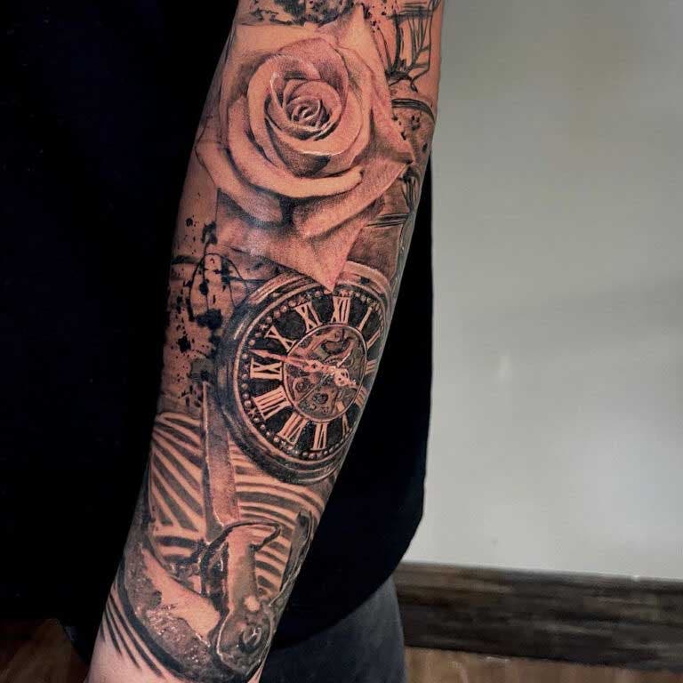 Tatouage d’ancre, de montre de poche et de fleur sur l’avant-bras 