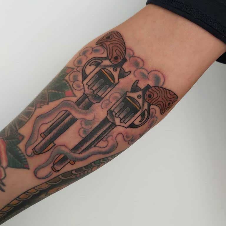 Tatouage d’armes à feux stylisées sur l’avant-bras