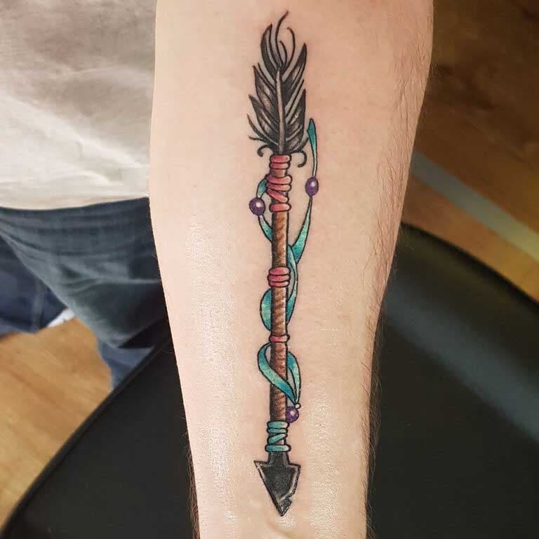 Tatouage de flèche en couleurs sur l’avant-bras 