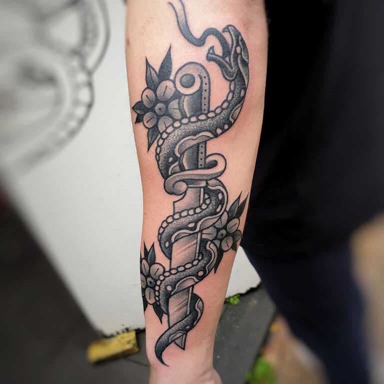 Tatouage de poignard et de serpent sur l’avant-bras