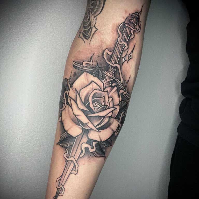 Tatouage de poignard et de rose sur l’avant-bras 